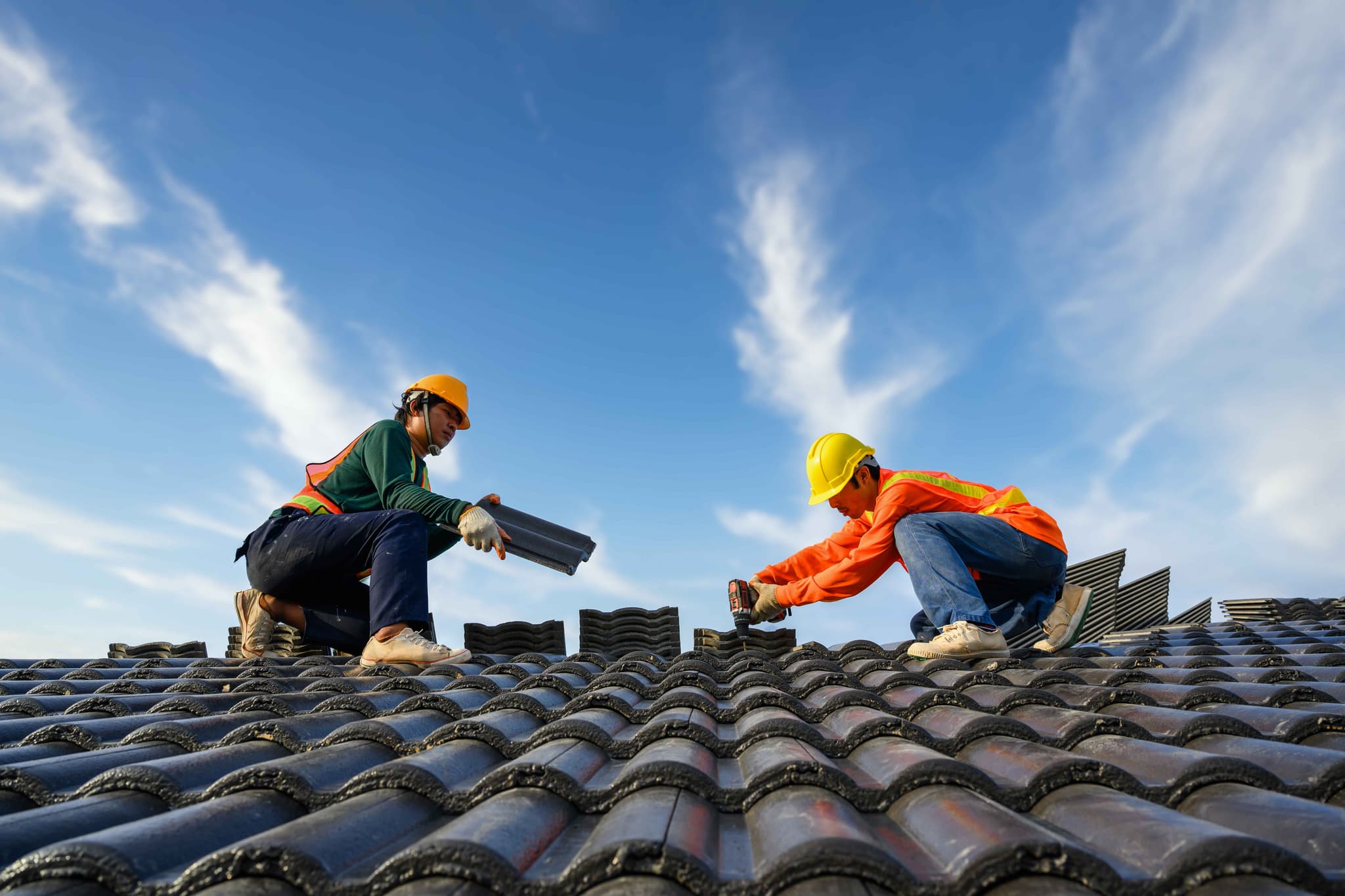 asian-male-roof-installer-asian-construction-workers-roof-work-using-drill
